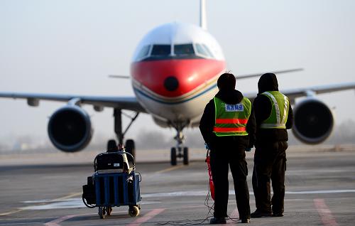 1月15日,在蘭州中川機(jī)場(chǎng),李木麗(左)和同事迎接一架飛機(jī)降落。新華社記者 張錳 攝