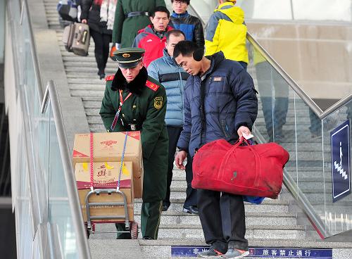 1月16日,在寧夏銀川火車(chē)站,一名武警戰(zhàn)士幫助旅客搬運(yùn)行李。新華社記者 彭昭之 攝