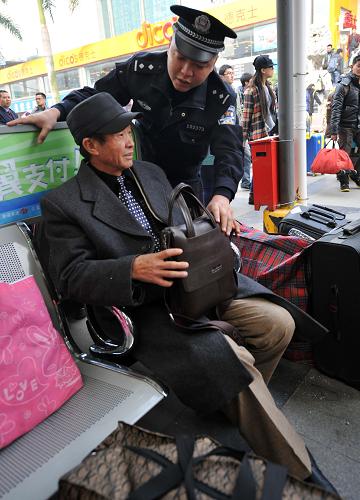 1月16日,在南寧火車(chē)站,一名乘警提醒旅客妥善保管自己的物品。新華社記者 劉廣銘 攝