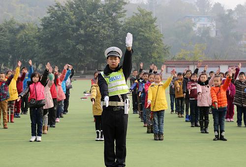 1月17日,重慶市武隆縣仙女山鎮(zhèn)希望小學(xué)的孩子們在民警鐘熙山的帶領(lǐng)下學(xué)習(xí)交通手勢操。新華社記者 陳誠 攝