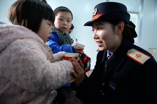 2月8日,在南昌火車站重點旅客服務區(qū)內(nèi),客運員李蘭敏為候車小乘客遞上熱水。春節(jié)長假結(jié)束,南昌鐵路局迎來旅客返程高峰。為方便老、幼、病、殘、孕等特殊乘客,南昌火車站搭建了150平方米的重點旅客服務區(qū),內(nèi)設(shè)兒童娛樂區(qū)和哺乳區(qū),配備空調(diào)、熱水爐等便民設(shè)施用品,為有需要的旅客免費提供溫暖舒適的候車環(huán)境。新華社發(fā)(陳子夏 攝)