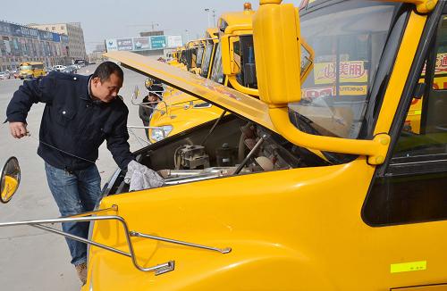 2月17日,校車司機(jī)李海軍查看校車機(jī)油情況,做進(jìn)站檢測(cè)前的準(zhǔn)備。新華社發(fā)(李榮新 攝)