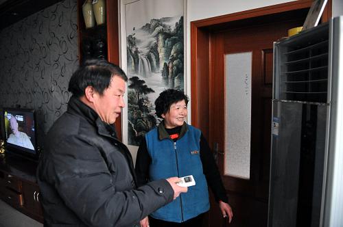 2月19日,仲宮鎮(zhèn)南劉家峪村村民李德平(左)和妻子在開空調(diào)采暖。農(nóng)網(wǎng)改造后,村民不再擔(dān)心使用大功率電器“跳閘”的難題。新華社記者 朱崢 攝