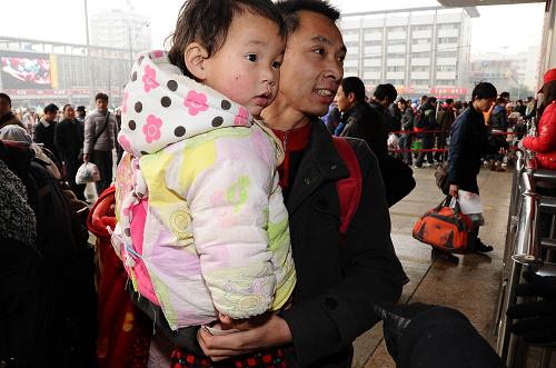 1月19日,在成都火車站,一名旅客抱著孩子進(jìn)站乘車。 據(jù)成都鐵路局介紹,2011年春運(yùn)期間,成都鐵路局預(yù)計(jì)發(fā)送旅客1850萬(wàn)人,比2010年增加211萬(wàn)人。 新華社記者陳凱攝
