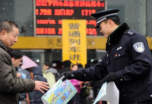 1月19日,一名民警在成都火車站外向旅客發(fā)放安全宣傳單。 據(jù)成都鐵路局介紹,2011年春運(yùn)期間,成都鐵路局預(yù)計(jì)發(fā)送旅客1850萬(wàn)人,比2010年增加211萬(wàn)人。 新華社記者陳凱攝