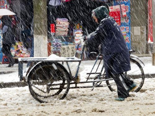 湖南多個縣市降暴雪 冰凍范圍有所加大 1月19日,行人冒雪推車行走在湖南省新邵縣街頭。 氣象資料顯示,18日8時至19日8時,湖南省內(nèi)持續(xù)暴雪、冰凍天氣。全省共有40縣市降雪(雨)量7.5毫米,達(dá)到大到暴雪量級,其中邵陽、新邵、武岡、漣源、雙峰等共20縣市降雪量超過10毫米,達(dá)到暴雪量級。此外,湖南省內(nèi)冰凍范圍較18日有所加大,強(qiáng)度加強(qiáng)。 新華社發(fā)(呂建設(shè) 攝)