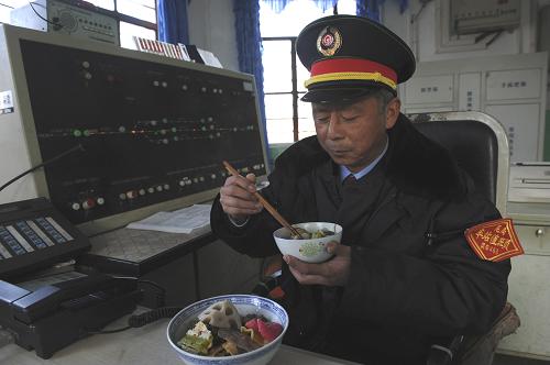 2月2日,南昆鐵路新安車站堅守崗位的昆明車務段值班員郭建波在吃年夜飯。新華社發(fā)(汪建云 攝)