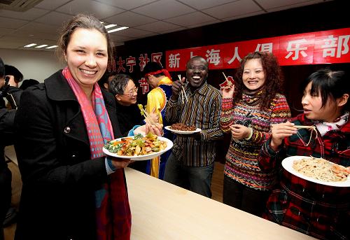 2月3日,來自俄羅斯的留學(xué)生伊娜(左一)在“百家宴”上品嘗社區(qū)鄰居的拿手好菜。新華社記者 陳飛 攝