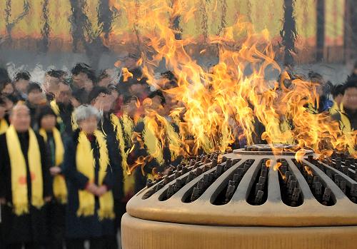 2月3日,朝拜者們站在軒轅黃帝紀念館外的圣火盆前參加拜祖活動。新華社記者王頌攝