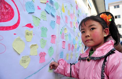 2月3日,甘肅舟曲縣城關(guān)二小三年級學生9歲的楊潔,在心愿墻上貼下自己書寫的新年心愿。當日,700多名舟曲縣中小學生聚集在一起,在上海增愛基金會、中科院心理研究所、舟曲縣教育局組織的“暖春增愛、給力舟曲”活動中書寫新年心愿,表達新年祈愿和心聲。新華社記者 梁強 攝