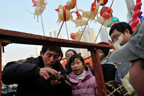 2月3日,在2011沈陽新春皇寺廟會上,民間藝人(左一)展示吹糖人技藝。當(dāng)日,為期15天的2011沈陽新春皇寺廟會拉開帷幕。市民在本屆廟會上不僅能品嘗風(fēng)味小吃,看到糖畫、吹糖人、捏面人、刻葫蘆、蛋雕等民間手工藝展示,還能欣賞模仿秀、器樂演奏以及風(fēng)格各異的秧歌表演等。新華社發(fā)(王朝輝 攝)
