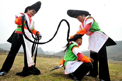 2月6日,在貴州省貴陽市花溪區(qū)沙坪村,苗族姑娘在參加跳洞活動(dòng)前梳頭裝扮。新華社發(fā)(吳東俊 攝)
