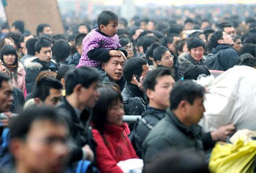 2月18日,一個(gè)孩子坐在爸爸肩上在鄭州火車站進(jìn)站。新華社記者 趙鵬 攝