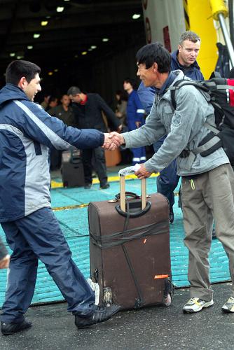 2月26日,在希臘克里特島,希臘服務(wù)人員和從利比亞撤離至此的中方人員握手。2898名中方人員乘坐中國(guó)駐希臘大使館租用的“韋尼澤洛斯”號(hào)客輪于當(dāng)?shù)貢r(shí)間26日上午抵達(dá)克里特島。 新華社發(fā)(馬里奧斯·羅洛斯 攝)