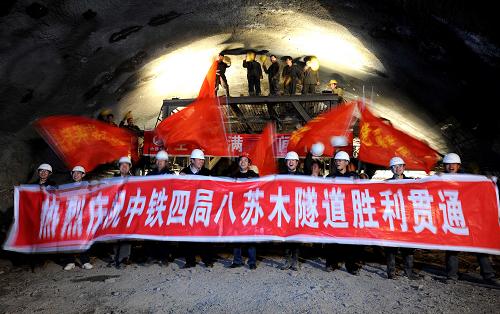 3月15日,中鐵四局二公司職工在集包鐵路增建第二雙線八蘇木隧道內(nèi)歡呼。當(dāng)日,經(jīng)過中鐵四局千余名建設(shè)者33個月的艱苦施工,京包快速鐵路集包段(集寧至包頭)增建第二雙線頭號控制工程——八蘇木隧道順利貫通,這座內(nèi)蒙古在建鐵路最長隧道、也是集包鐵路增建第二雙線施工難度最大的隧道難題被全面攻克。由中鐵四局二公司承建的八蘇木隧道屬雙線特大斷面隧道,全長8184米,開挖斷面在110平方米以上,最大埋深約130米。地質(zhì)情況異常復(fù)雜,施工技術(shù)難度非常大,屬于該鐵路線上的高風(fēng)險工程,施工技術(shù)人員有效克服了地質(zhì)情況的變化對工期產(chǎn)生的制約因素,取得了異常復(fù)雜地質(zhì)條件下大隧道技術(shù)施工經(jīng)驗和安全管理成效。京包鐵路集寧至包頭段增建第二雙線工程是“十一五”期間我國鐵路“八縱八橫”鐵路網(wǎng)主骨架的重要組成部分,全長308公里,將于2011年底建成通車。屆時,呼和浩特與北京之間的客車運行時間將由現(xiàn)在的10多個小時縮短為2小時左右,同時將有效緩解京藏高速公路的運輸壓力,提高能源輸出運能,為構(gòu)建內(nèi)蒙古與京津唐地區(qū)資本、技術(shù)、人才優(yōu)勢互補、社會經(jīng)濟可持續(xù)發(fā)展提供保障。 新華社記者 張領(lǐng) 攝