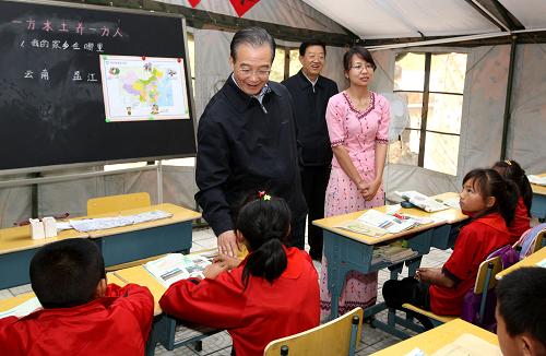 這是3月18日,溫家寶來到盈江縣平原鎮(zhèn)崗勐中心小學(xué)的帳篷教室,看望學(xué)生們。新華社記者 姚大偉 攝