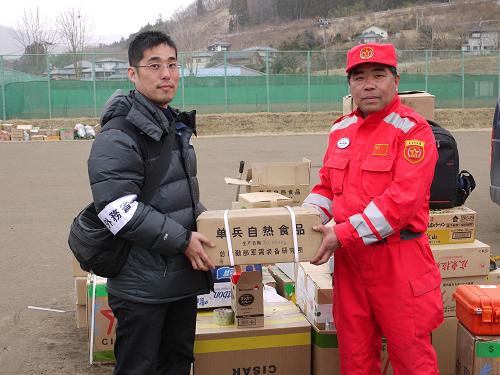 3月20日,在日本巖手縣大船渡地震海嘯災(zāi)區(qū)的中國國際救援隊駐地內(nèi),中國國際救援隊領(lǐng)隊尹光輝(右)向日本災(zāi)區(qū)捐贈部分食品等生活物資。新華社記者 劉華 攝