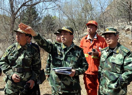 4月15日,前方指揮人員在東峪林場火點附近指揮滅火。 當(dāng)日,記者從秦皇島“4·12”森林大火撲救工作指揮部獲悉,經(jīng)過廣大官兵和當(dāng)?shù)馗刹咳罕姷木o張撲救,到14日21時,四號區(qū)域明火已全部撲滅,一、二、三號區(qū)域火勢得到有效控制。但由于14日夜間的6-7級大風(fēng),且風(fēng)向由南向北轉(zhuǎn)移,方家河、東峪林場以南和以東地區(qū)再次出現(xiàn)火點,目前正在積極組織撲救,同時將根據(jù)天氣進(jìn)行人工增雨作業(yè)。 4月12日中午,河北省秦皇島市撫寧縣和青龍縣交界處突發(fā)森林火災(zāi)。 新華社記者 楊世堯攝
