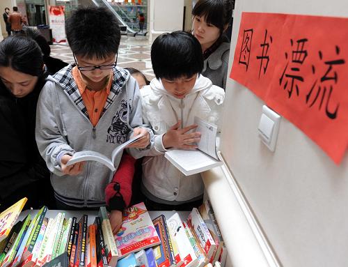 4月23日,哈爾濱學(xué)生在“圖書漂流”區(qū)域挑選圖書。當(dāng)日,黑龍江省圖書館啟動世界讀書日暨2011全民讀書月系列活動,包括“圖書漂流”、優(yōu)秀圖書展、公益講座和部分閱覽室免費開放在內(nèi)的一系列活動讓讀者享受到閱讀帶來的樂趣。新華社記者 王松 攝