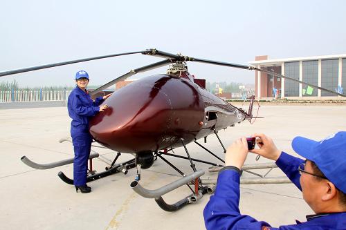 5月7日,一名工作人員在V750無(wú)人直升機(jī)前留影。新華社發(fā)(孫樹寶 攝)