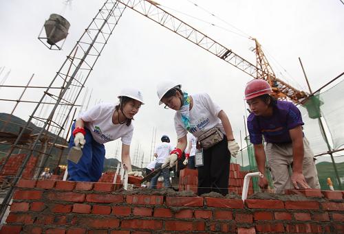 5月9日,在重災區(qū)四川省青川縣竹園鎮(zhèn),幾名志愿者在援建的安居房工地勞動。四川汶川大地震近3年來,地震災區(qū)的重建牽動著社會各界。當日,來自香港迪斯尼樂園、國際公益組織“仁人家園”等單位的志愿者再次來到重災區(qū)青川縣,參與到當?shù)貫拿癜仓眯^(qū)建設的施工中,為災區(qū)群眾早日住進新居添磚加瓦。 新華社記者 任正來 攝