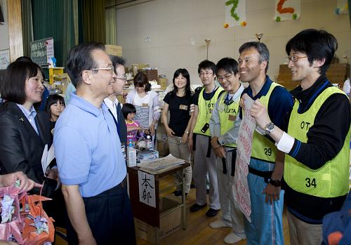 5月21日,中國國務(wù)院總理溫家寶在日本名取市館腰小學(xué)體育館災(zāi)民避難所慰問受災(zāi)民眾。這是溫家寶在與日本青年交流。 新華社記者黃敬文攝
