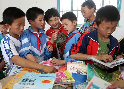 5月26日,江西九江市修水縣東港鄉(xiāng)桂坳村小學(xué)學(xué)生在翻閱“愛心捐書之旅”活動捐贈的圖書新華社發(fā)(顧偉東 攝)