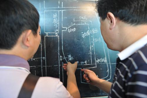 5月30日,工作人員在礦井示意圖前研究救援方案。新華社記者 歐東衢 攝