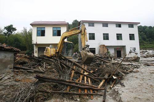 6月11日,在湖南岳陽(yáng)臨湘市詹橋鎮(zhèn)云山村,搶險(xiǎn)人員駕駛挖掘機(jī)展開(kāi)清理工作。新華社發(fā)