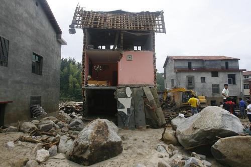 6月11日,在湖南岳陽(yáng)臨湘市詹橋鎮(zhèn)云山村,當(dāng)?shù)鼐用裨诒粴牡拿穹恐虚_(kāi)展搜救清理工作。新華社發(fā)