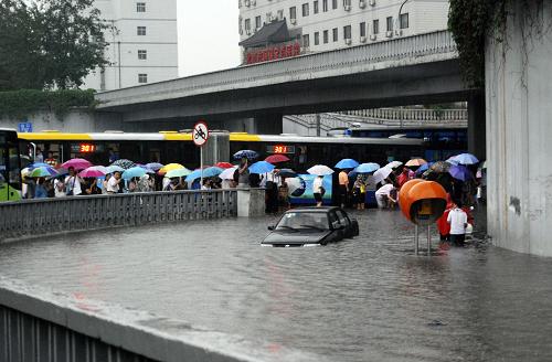 6月23日,在北京西三環(huán)蓮花橋附近,車輛和市民涉水前行。當(dāng)日下午,北京遭遇強(qiáng)雷雨天氣,白晝?nèi)缫梗o行人出行帶來(lái)不便。新華社發(fā)