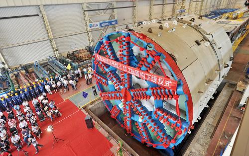 這是7月2日拍攝的北京地鐵14號線“吉祥九號”盾構(gòu)機(jī)下線儀式現(xiàn)場。當(dāng)日,專為北京地鐵14號線15標(biāo)段隧道施工制造生產(chǎn)的盾構(gòu)機(jī)——“吉祥九號”在河北秦皇島正式下線。該盾構(gòu)機(jī)主體總長度11.55米(不含工作臺及螺旋輸送機(jī)長度),盾殼最大直徑10.22米,開挖直徑10.26米,最大掘進(jìn)速度為每分鐘8.5厘米,是目前國內(nèi)地鐵施工采用的最大直徑土壓平衡式盾構(gòu)機(jī)。該盾構(gòu)機(jī)采用新的“一洞雙線”工程技術(shù),可有效減少地鐵建設(shè)中的拆遷量和施工占地面積,比以往節(jié)省約40%的施工量。新華社發(fā)(劉學(xué)忠 攝)