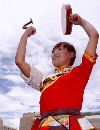 7月17日,身著民族服裝的藏族青年在拉薩賓館前載歌載舞,歡迎參加西藏和平解放60周年慶?;顒?dòng)的中央代表團(tuán)抵達(dá)拉薩。 新華社記者陳建力攝