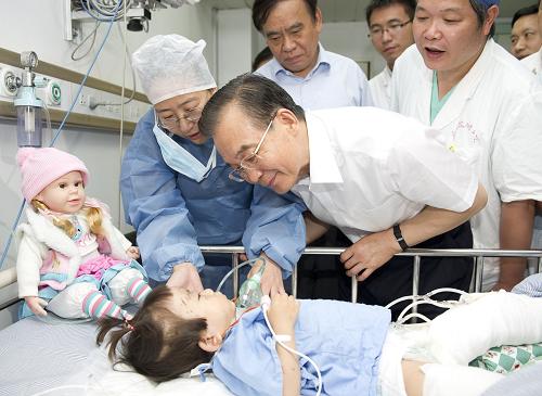 7月28日,中共中央政治局常委、國務(wù)院總理溫家寶來到浙江溫州,察看“7·23”甬溫線特別重大鐵路交通事故現(xiàn)場,悼念遇難者,看望受傷人員,對傷亡人員家屬表示深切慰問。這是溫家寶特地來到溫州醫(yī)學(xué)院附屬第二醫(yī)院看望小伊伊。兩歲零八個月的小女孩項煒伊是這起事故最后一名獲救者。新華社記者 黃敬文 攝
