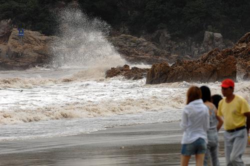 8月6日,幾位居民在浙江象山附近海域觀看“梅花”帶來(lái)的巨大海浪。新華社記者 鞠煥宗 攝