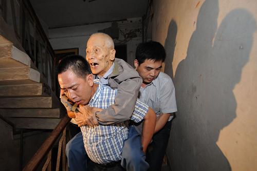 8月6日,工作人員將舟山市定海區(qū)解放街道翁山社區(qū)85歲的鄭啟云老人背出危房,準(zhǔn)備送到附近的一處賓館。新華社記者 韓傳號(hào) 攝