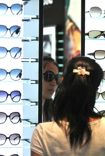 一名女士在免稅店內(nèi)選購(gòu)眼鏡(8月12日攝)。新華社記者 侯建森 攝