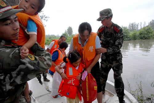 安徽淮南兩千余名受困群眾全部安全轉移 8月27日,安徽淮南武警在轉移鳳臺縣的受災群眾。 8月26日7時至27日14時,安徽省淮南、蚌埠等地降大暴雨、特大暴雨,鳳臺、懷遠和固鎮(zhèn)等地有23個鄉(xiāng)鎮(zhèn)超過200毫米。受強降雨影響,淮南市鳳臺縣丁集礦采煤沉陷區(qū)范圍內的關店鄉(xiāng)3個行政村的7個自然莊2470名群眾被水圍困。淮南市縣兩級啟動搶險救災應急預案,調集武警消防部隊及沖鋒舟轉移群眾。到27日18時,2470名被水圍困群眾已全部安全轉移。 新華社發(fā)