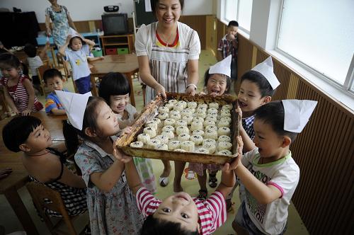 9月9日,浙江省東陽(yáng)市婦聯(lián)幼兒園的小朋友把做好的月餅抬去烘烤。當(dāng)日,浙江省東陽(yáng)市婦聯(lián)幼兒園組織小朋友開(kāi)展“學(xué)做中秋月餅,體驗(yàn)傳統(tǒng)文化”活動(dòng),讓孩子們?cè)谥谱髟嘛炛懈惺軅鹘y(tǒng)文化的魅力,迎接中秋節(jié)的到來(lái)。新華社發(fā)(包康軒 攝)