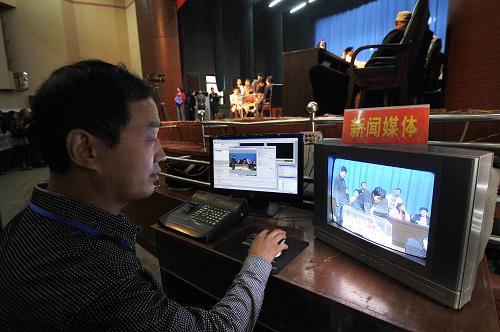 9月9日,在山西萬榮縣2011年首批324套經(jīng)濟適用住房公開抽號現(xiàn)場,一名新聞工作者在報道抽號過程。新華社發(fā)(閆鑫 攝)