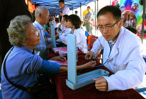 9月24日,一名山東省地方病防治研究所的醫(yī)生在為濟南市民測量血壓。當(dāng)日,25家駐濟南的省部屬醫(yī)療機構(gòu)和濟南市的19家醫(yī)療衛(wèi)生單位在濟南市泉城廣場開展義診服務(wù)活動。此次活動是山東省衛(wèi)生系統(tǒng)“三好一滿意”宣傳服務(wù)日活動的組成部分之一。與此同時,山東全省17地市也都有醫(yī)療機構(gòu)開展了義診服務(wù),并進行健康咨詢、贈送藥品、發(fā)放醫(yī)療服務(wù)便民手冊等公益服務(wù)。新華社記者 徐速繪 攝