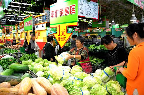 9月25日,市民在連云港一家大型超市的農(nóng)副產(chǎn)品平價直銷區(qū)內(nèi)選購低價蔬菜。日前,江蘇連云港市首批15家“農(nóng)副產(chǎn)品平價直銷店”已正式掛牌運營。該市通過實施“112”平價商店工程,即在10家符合條件的大中型超市建立直銷專柜,在10家農(nóng)貿(mào)市場開辟直銷區(qū),設(shè)立20個社區(qū)直銷點,以穩(wěn)定蔬菜價格。其中,超市直銷專柜的蔬菜價格須比全市均價低15%,并且每天要供應(yīng)不少于5個品種、價格低于1元/斤的蔬菜。新華社發(fā)(王春 攝)