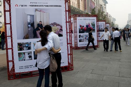 9月25日,觀眾在北京王府井步行街觀看“廣廈萬(wàn)間”攝影展。新華社記者 劉杰 攝