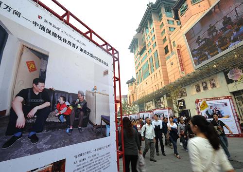 9月25日,北京王府井步行街的過(guò)往游客在觀看展覽。新華社記者 羅曉光 攝