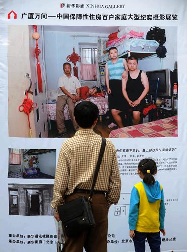 9月25日,北京王府井步行街的過(guò)往游客在觀看展覽。新華社記者 羅曉光 攝