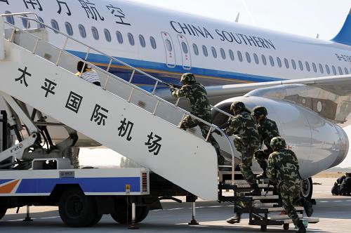9月26日,狙擊手擊斃一名“恐怖分子”后,武警戰(zhàn)士立即沖上飛機。當日,“利劍·2011”反劫機綜合演練在黑龍江哈爾濱太平國際機場舉行。演習模擬“恐怖分子”強行闖入飛行控制區(qū),企圖劫持一架飛機,以機組人員和機上乘客為人質,要求飛機飛往境外,相關部門立即啟動應急預案處置事件。新華社發(fā)(王凱攝)