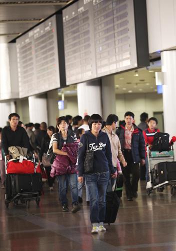 9月30日深夜,一批剛乘飛機(jī)抵達(dá)的旅客從北京首都機(jī)場(chǎng)2號(hào)航站樓走出。 新華社發(fā)(梁志強(qiáng) 攝)
