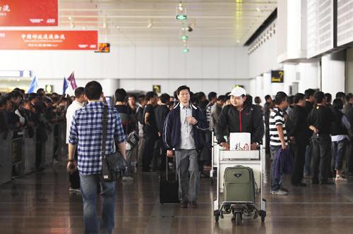 10月1日凌晨,剛乘飛機(jī)抵達(dá)的旅客從北京首都機(jī)場(chǎng)2號(hào)航站樓走出。新華社發(fā)(梁志強(qiáng) 攝)
