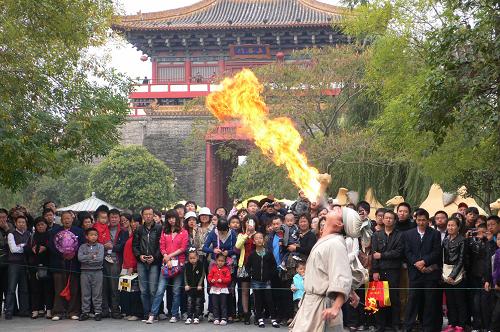 10月2日,眾多游客在河南開封市清明上河園觀看氣功噴火表演。當日是國慶長假第二天,河南開封市公園景點里來自四面八方的游客絡繹不絕,豐富多彩的民俗文化表演讓游人大飽眼福。新華社 發(fā)
