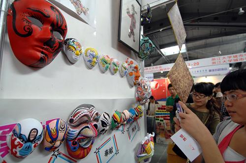 10月3日,參觀者在參觀展出的大學(xué)生手繪臉譜面具。新華社記者 鞠煥宗 攝